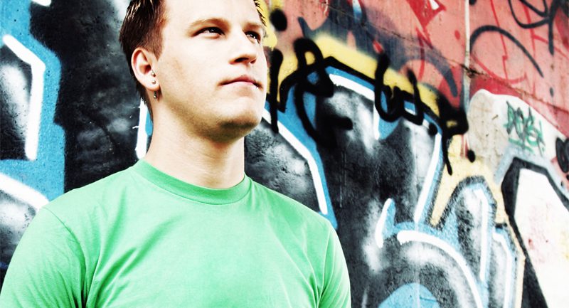 Young male in front of graffiti wall