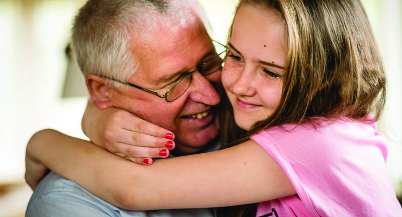Young girl in pink top hugging smiling man Young girl in pink top hugging smiling man