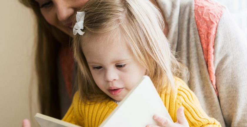 Young girl in yellow top reading book