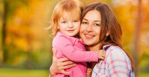 Woman hugging young girl in pink