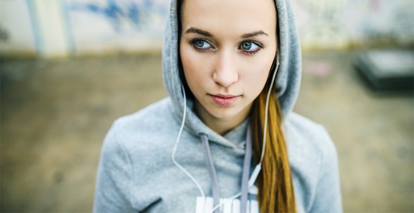 Girl with long hair hood up listening to music