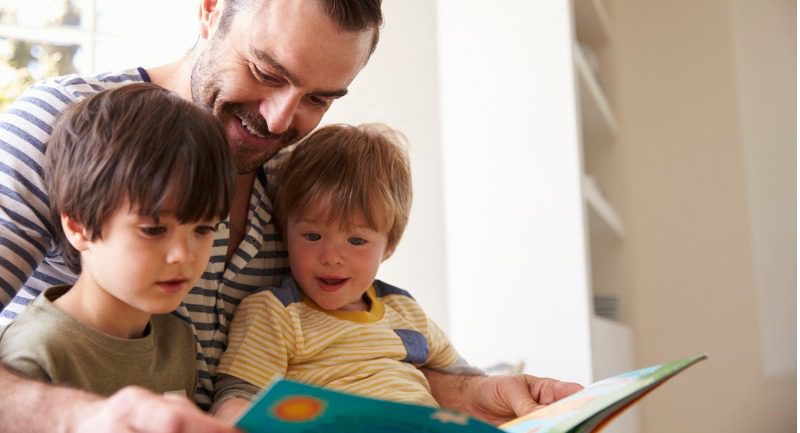 father-and-sons-reading-story-at-home father-and-sons-reading-story-at-home