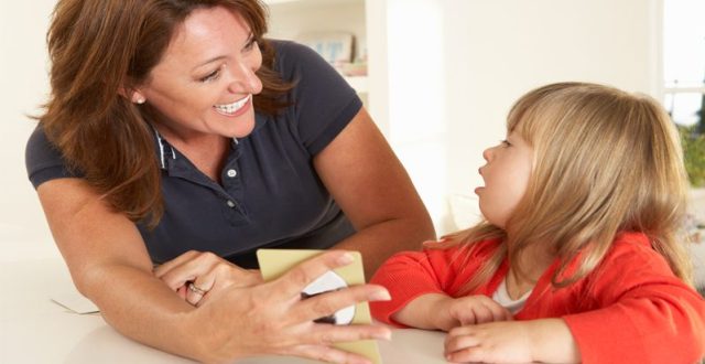 Young girl being shown card by smiling woman