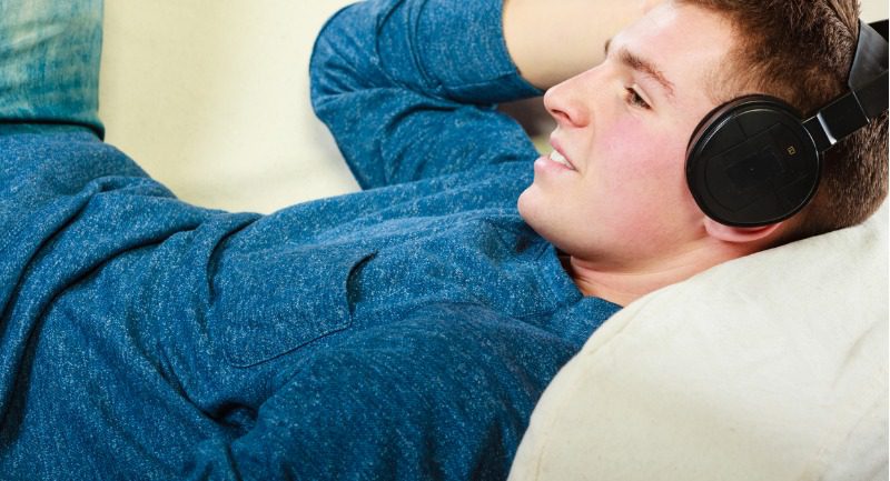 young-man-with-headphones-lying-on-couch-picture