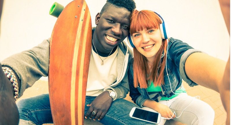 hipster-multiracial-couple-in-love-taking-selfie-with-longboard