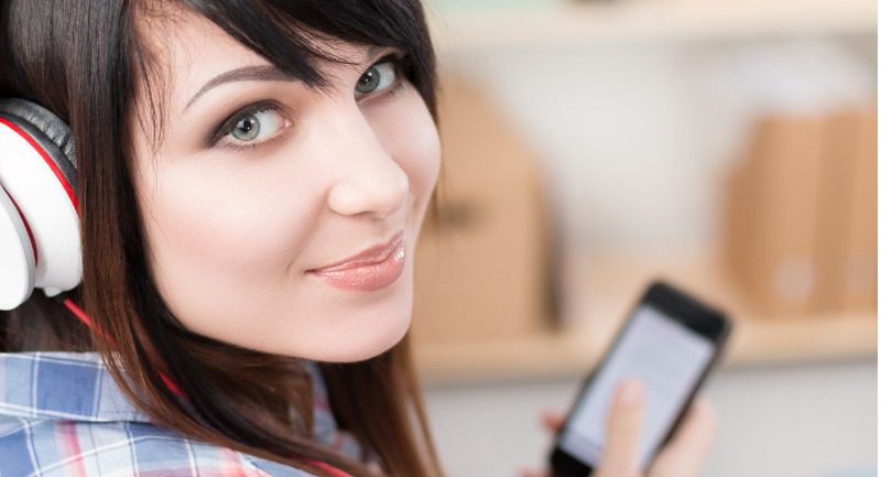 young-brunette-woman-in-headphones-holding-mobile-phone- young-brunette-woman-in-headphones-holding-mobile-phone-