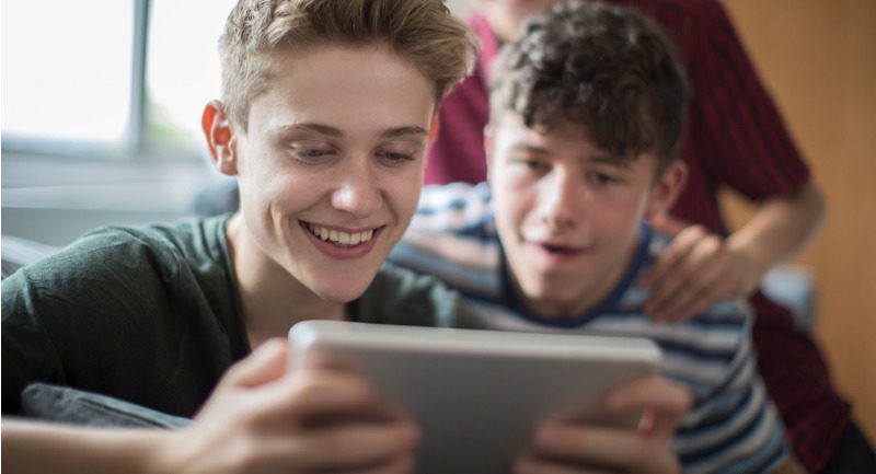 three-teenage-boys-playing-game-on-digital-tablet-at-home