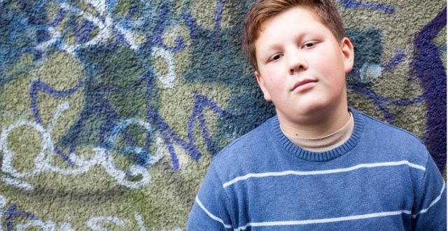 teenage-boy-portrait-in-front-of-graffiti-wall