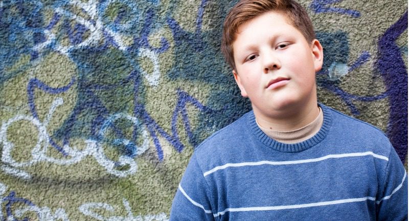 teenage-boy-portrait-in-front-of-graffiti-wall