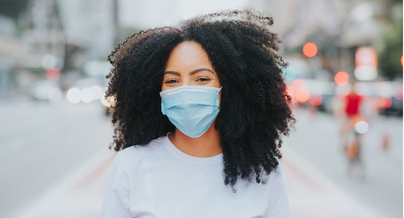 Young woman with long black hair wearing a medical face mask