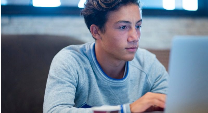 Portrait of a teenage boy using a laptop
