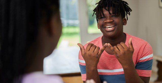 Teenage boy and girl having a conversation using sign language