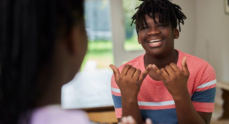 Teenage boy and girl having a conversation using sign language