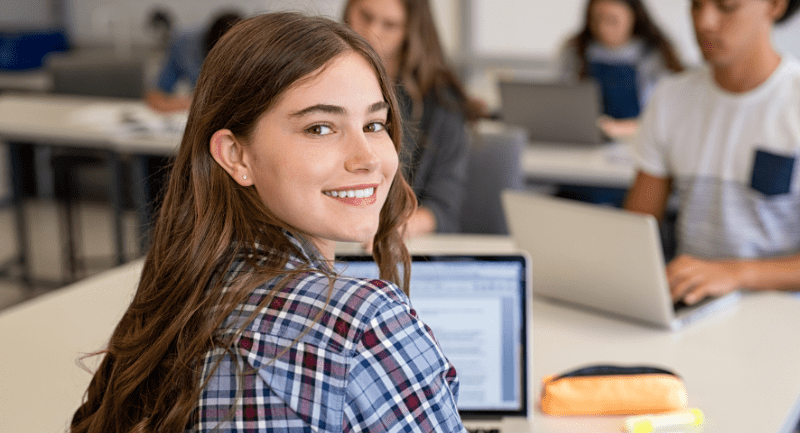 Young woman smiling while using a laptop