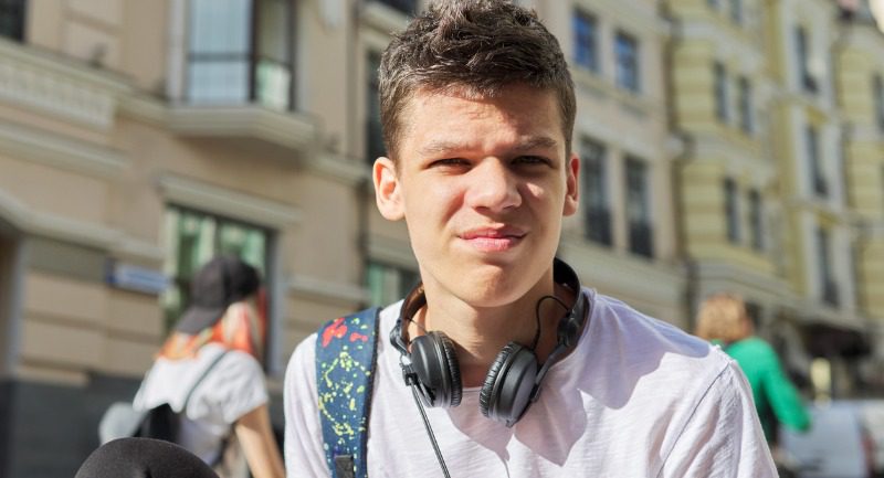 Young teenage man with headphones round his neck