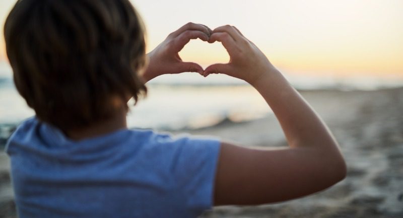 A young woman making a heart shape with her hands