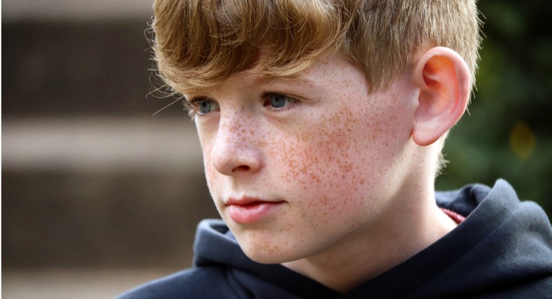 a young boy with freckles and short brown hair