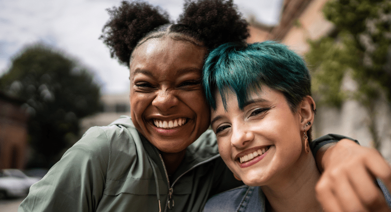 Portrait of friends embracing in the street