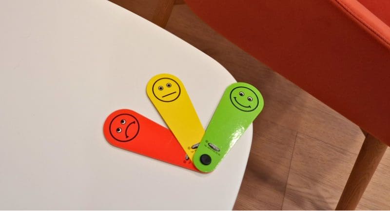 A red, yellow and green mini fan. Each fan has a different emotion on them.