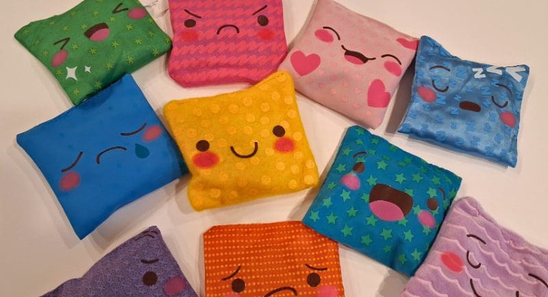 Multiple colorful bean bags each with a different emotion on them