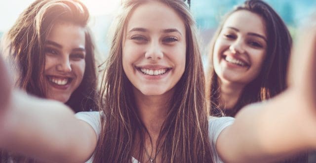 Group of Smiling Girls Taking Selfie and Making Faces Outdoors