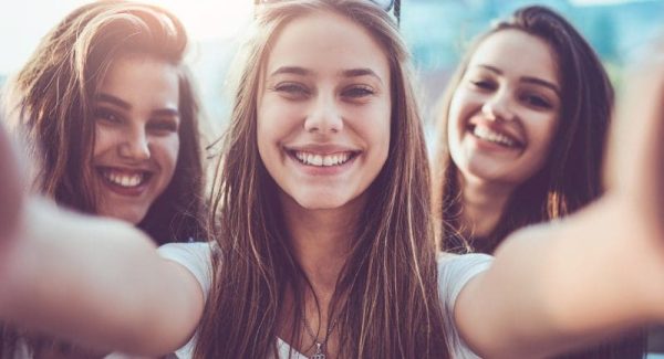 Group of Smiling Girls Taking Selfie and Making Faces Outdoors